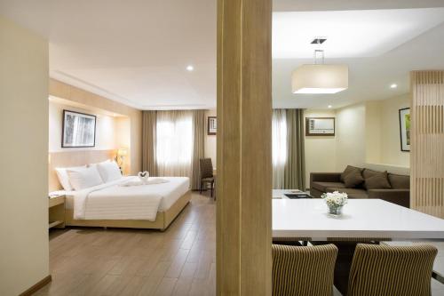 a hotel room with a bed and a living room at Golden Prince Hotel & Suites in Cebu City