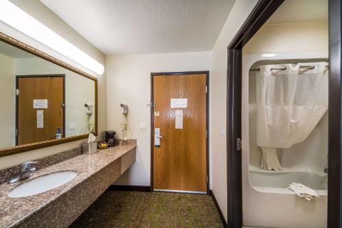 a bathroom with a sink and a mirror and a shower at Quality Suites San Antonio Brooks City Base in San Antonio
