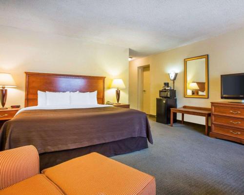 a hotel room with a bed and a television at Budgetel Inn & Suites Atlanta in Atlanta