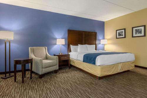 a hotel room with a bed and a chair at Suburban Studios Arlington Heights Elk Grove in Arlington Heights