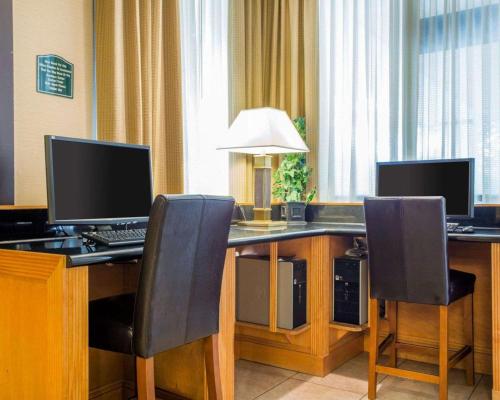 a desk with two computer monitors and two chairs at Budgetel Inn & Suites Atlanta in Atlanta