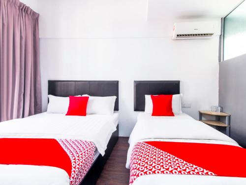two beds in a room with red and white sheets at Intime Hotel Kuchai Lama Kuala Lumpur in Kuala Lumpur