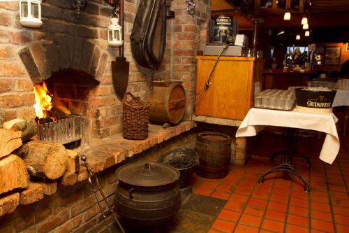 a kitchen with a brick oven and a table and a table at Lynhams Hotel in Laragh
