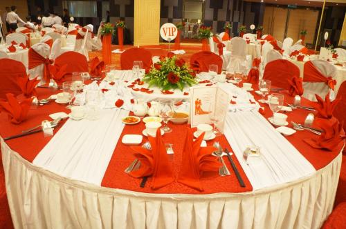 a long table with white tables and red chairs at Sabah Oriental Hotel in Kota Kinabalu