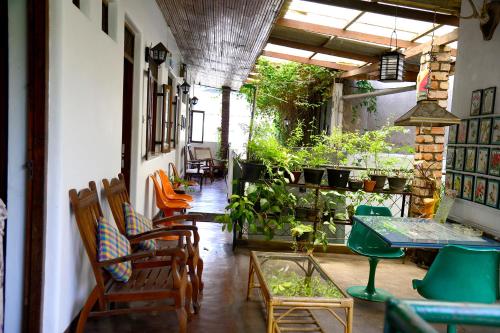 a room with chairs and a table and a patio at Kandy Inn Madugalle’s family guest house in Kandy