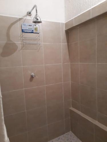 a bathroom with a shower with a tile wall at Martha´s HOUSE in Culiacán