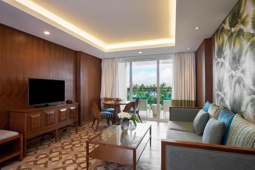 a living room with a couch and a television at Movenpick Resort & Spa Boracay in Boracay