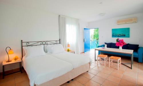 a bedroom with a bed and a table and a desk at Aliathon Aegean in Paphos City