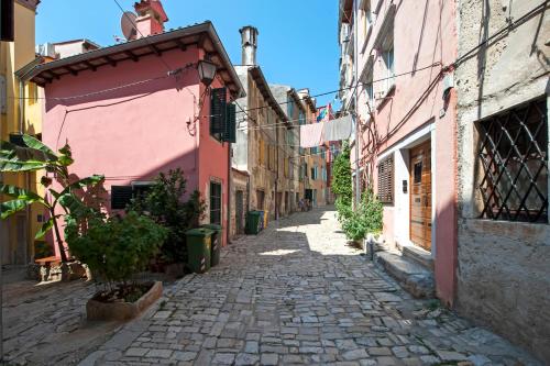 an alley in an old town with pink buildings at Villa Nea Seaview 3-apartments! in Rovinj