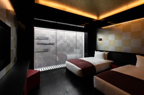 京都的住宿－eph KYOTO，酒店客房设有两张床和窗户。