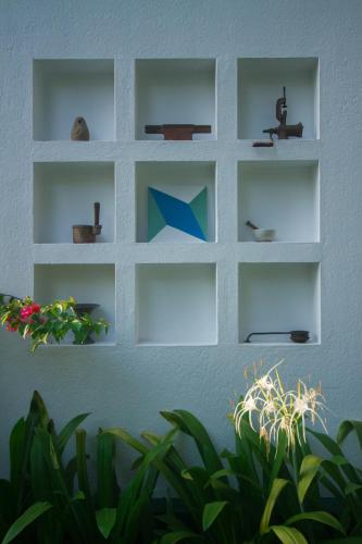 a wall with white shelves on a wall with plants at Villa Mia in Mararikulam