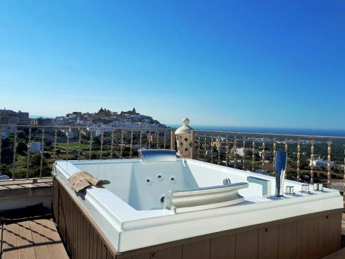 d'une baignoire installée au-dessus d'un balcon donnant sur l'océan. dans l'établissement Biancadamare, à Ostuni