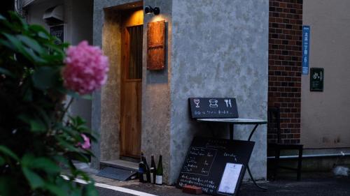 a building with a sign in front of a door at Beppu hostel&cafe ourschestra in Beppu