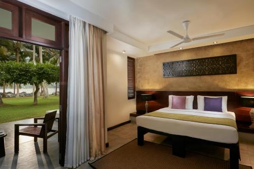 a bedroom with a bed and a large window at Avani Kalutara Resort in Kalutara
