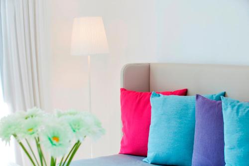a bunch of colorful pillows sitting on a couch at Aliathon Aegean in Paphos City