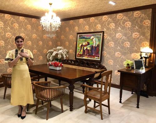 a woman standing in a room with a table at Golden Prince Hotel & Suites in Cebu City