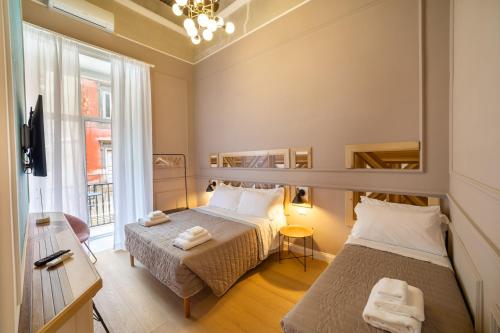 a bedroom with two beds and a window at The Duomo House by House In Naples in Naples