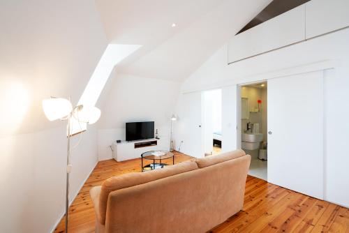 a living room with a couch and a television at Apartamentos Premium Familiares - Loft Guesthouse BeMyGuest Viseu in Viseu