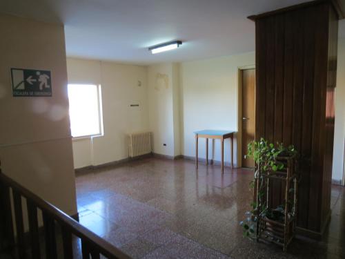 an empty room with a table and a hallway at Hotel Oviedo in Río Gallegos