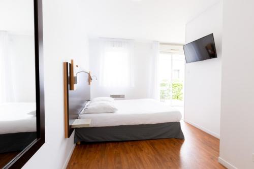 a bedroom with a bed and a mirror at Cerise Nantes Atlantis in Saint-Herblain