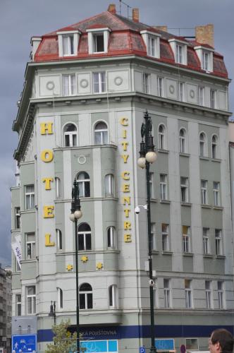 a white building with a yellow sign on it at City Centre in Prague