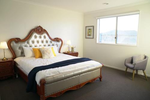 a bedroom with a bed and a window and a chair at Classic 6BRM Villa in Melbourne in Laverton