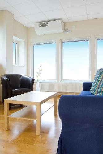 a living room with a coffee table and two chairs at Bohusgården Hotell & Konferens in Uddevalla