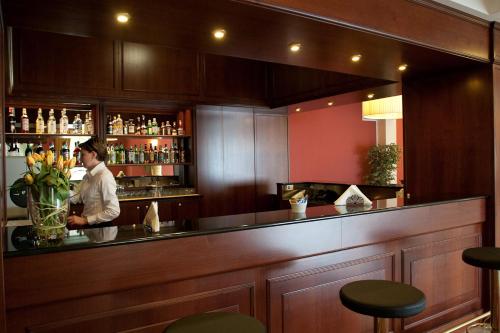 a man standing behind a bar in a restaurant at Hotel Maxim in Anzola dell'Emilia