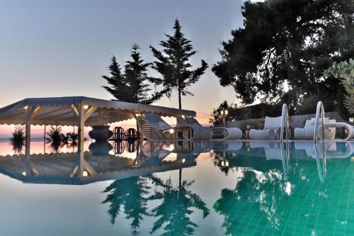 a pool of water with a pavilion in the middle at Acrotel Athena Villa in Elia