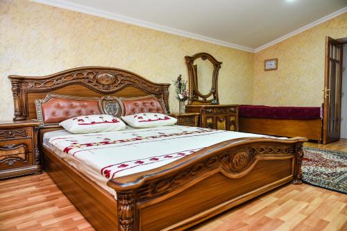 a bedroom with a large wooden bed in a room at Hotel S.R in Tbilisi City