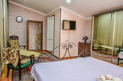 a bedroom with a bed and a chair at Hotel S.R in Tbilisi City