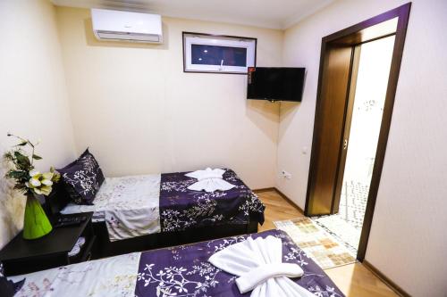 a small room with two beds and a mirror at Hotel S.R in Tbilisi City
