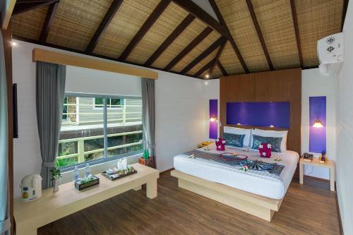 um quarto com uma cama grande e uma janela grande em PP Erawan Palms Resort- SHA Extra Plus em Phi Phi Don