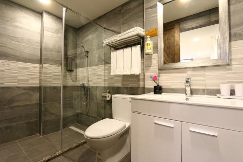 a bathroom with a toilet and a glass shower at Lukang Barn Inn in Lugang