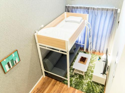 a small bedroom with a bunk bed in a room at TRIP POD HIGASHI-HIE in Fukuoka