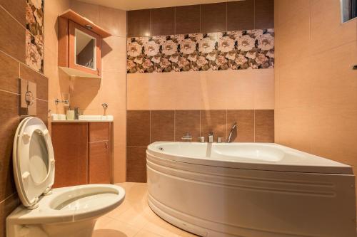 a bathroom with a tub and a toilet and a sink at Este apart 5 - Top center in Sofia