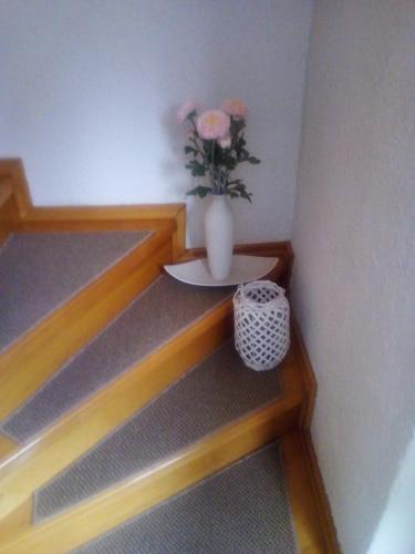 a vase with pink flowers sitting on a shelf at Nika in Ogulin