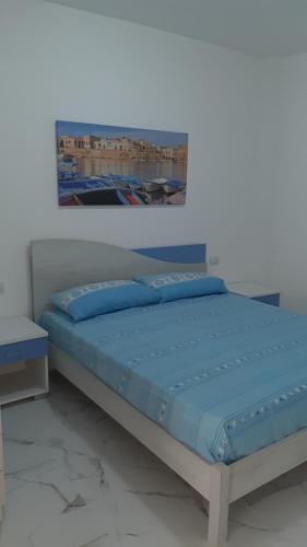 een slaapkamer met een bed met een foto aan de muur bij Il fortino in Otranto