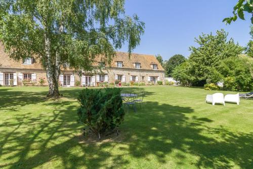 une maison avec un arbre et des chaises dans une cour dans l'établissement Domaine des Trois chateaux, à Moisenay