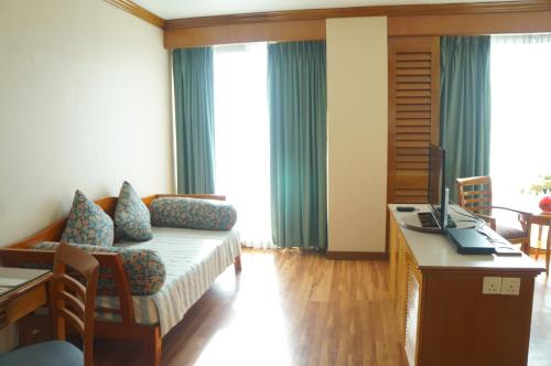 a living room with a couch and a desk with a computer at Sabah Oriental Hotel in Kota Kinabalu