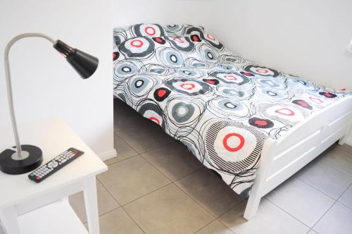 un lit avec une couette et un bureau avec une lampe dans l'établissement Domki Sara Piotr Maszke, à Białogóra