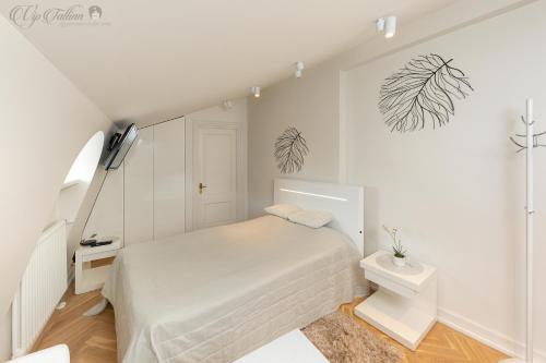 a white bedroom with a bed and a staircase at Vip Old Town Apartments in Tallinn