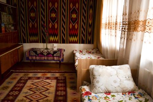 a small room with two beds and a rug at Guesthouse Bermet in Tong