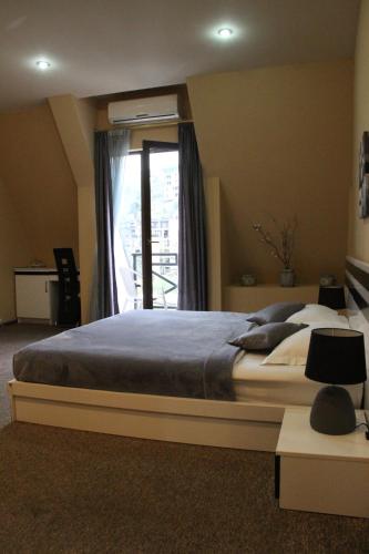 a bedroom with a large bed and a window at Hotel Diplomat in Tbilisi City