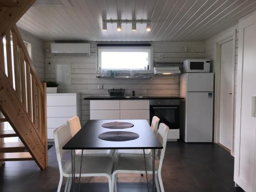 a kitchen with a table and chairs in a tiny house at Stugcentralen Stuga 24 in Halmstad