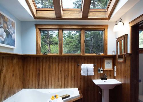 bagno con vasca, lavandino e finestre di Riversong Inn Retreat a Estes Park