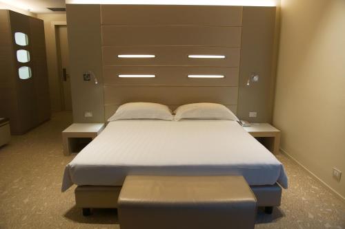 a bedroom with a bed and a large headboard at Best Western Plus Net Tower Hotel Padova in Padova