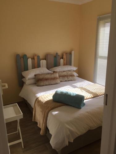 a bedroom with two twin beds with a headboard at Huisi by di C in Hermanus