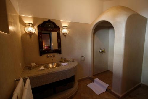 y baño con lavabo y espejo. en Riad Assakina, en Marrakech