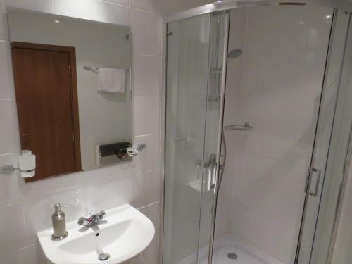 a bathroom with a sink and a shower with a mirror at Villa Park Apartment nr 216 in Borovets